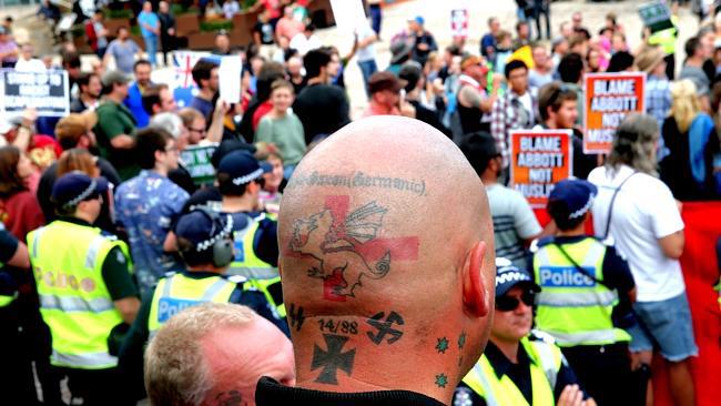 Bald man with racist icons tattooed on his head