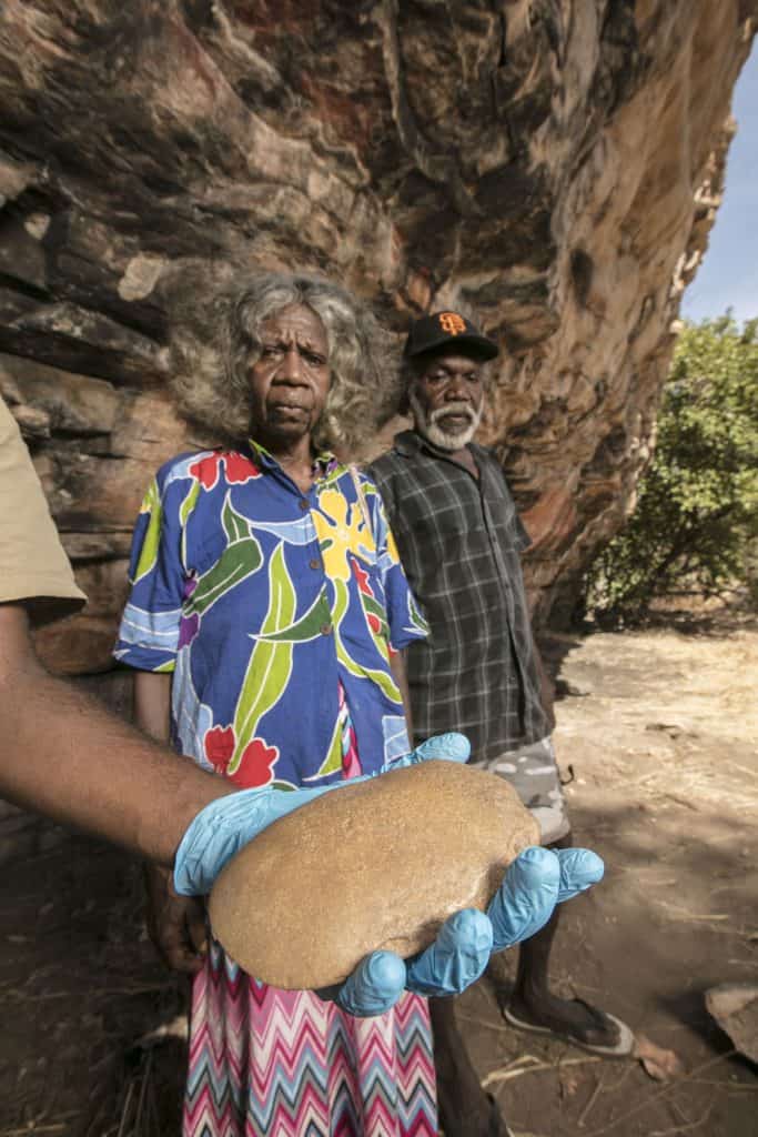 May Nango and Mark Djanjomerr inspect one of the artefacts uncovered at the Madjedbebe site.Photo: Glenn Campbell.