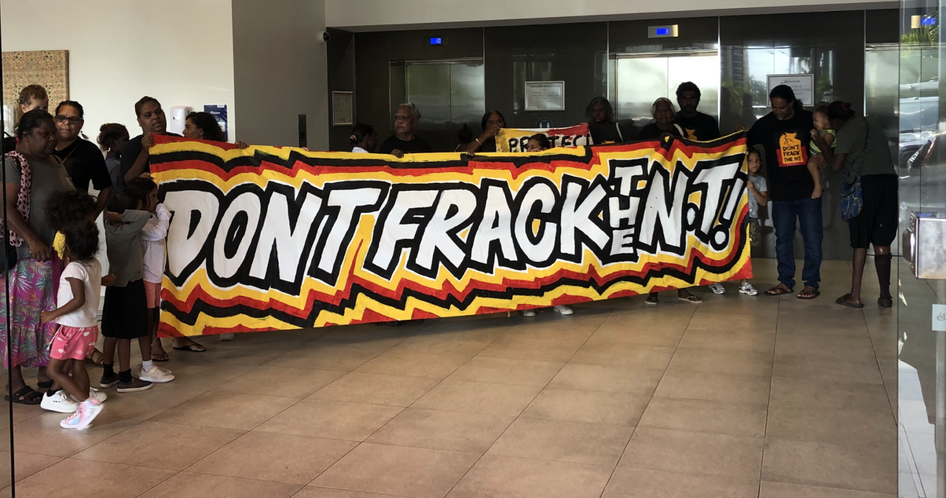 Group of Traditional Owners in the Northern Territory holding banner: Don't Frack The NT