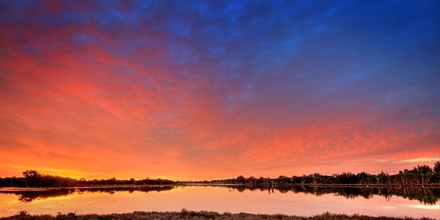 A red sky over a large body of water, which reflects the sky's colour.