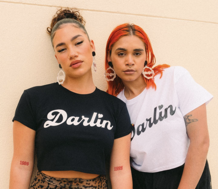 Two First Nations people wear t shirts that say 'Darlin'.